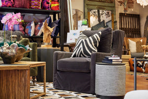 A grey velvet swivel chair with a zebra pillow and stunning bone inlay side table. 