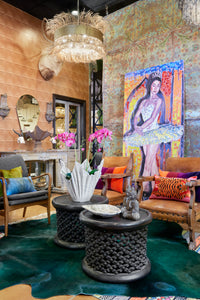 Layers of color and texture, with a green hide rug, chairs, springbok pillows and a large ballerina painting.  