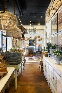 A row of planters, mirrors, tables and layers of table top decor. 