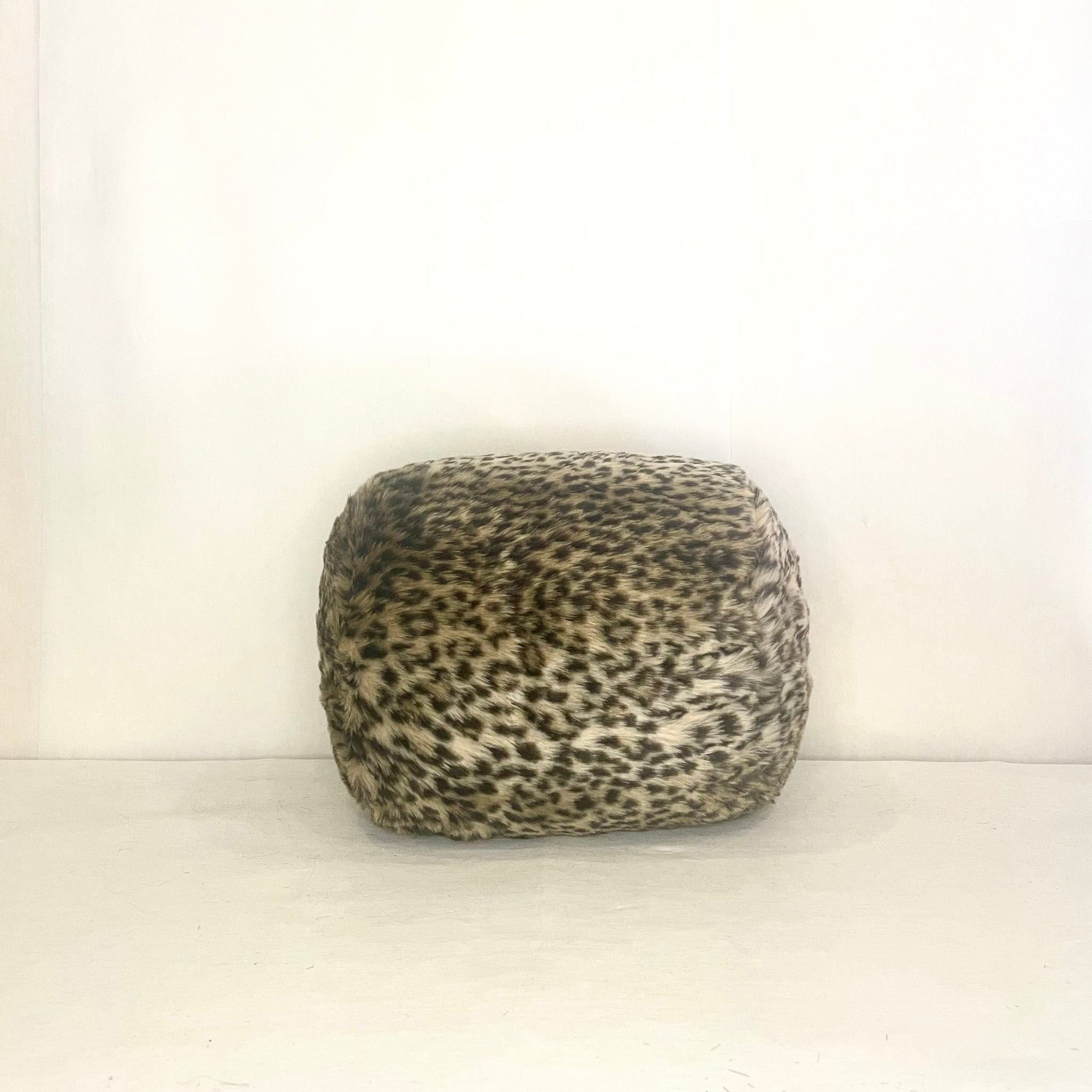 A mini bolster pillow with leopard print fabric. 